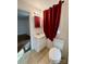 Cozy bathroom with modern sink and vanity, neutral tile, and window with dark red curtain at 3437 Wilkesboro Hwy, Statesville, NC 28625