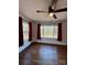 Bedroom featuring hardwood floors, ceiling fan, windows, and burgundy curtains at 3437 Wilkesboro Hwy, Statesville, NC 28625