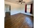Bedroom with hardwood floors, ceiling fan, window, entry doorway, and red curtains at 3437 Wilkesboro Hwy, Statesville, NC 28625