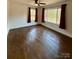 Bedroom featuring hardwood floors, ceiling fan, two windows, and burgundy curtains at 3437 Wilkesboro Hwy, Statesville, NC 28625
