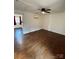 Bedroom with hardwood flooring, a ceiling fan, window A/C, and views into an adjacent room at 3437 Wilkesboro Hwy, Statesville, NC 28625