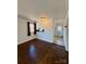 Dining room with dark hardwood floors, window, light fixture, and view into kitchen at 3437 Wilkesboro Hwy, Statesville, NC 28625
