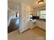 Well-organized kitchen with white cabinets, tile flooring, and view into the living area at 3437 Wilkesboro Hwy, Statesville, NC 28625