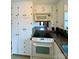 Kitchen showcasing white cabinets, countertops with tile backsplash, oven top, and microwave at 3437 Wilkesboro Hwy, Statesville, NC 28625