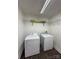 Functional laundry room with washer, dryer, wire shelving, and fluorescent lighting at 3437 Wilkesboro Hwy, Statesville, NC 28625