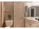 This bathroom features striped wallpaper, a toilet, a white vanity, and a large door at 423 Bethel Dr, Salisbury, NC 28144