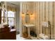 This powder room includes striped wallpaper, stained-glass window, pedestal sink, and wooden cabinet at 423 Bethel Dr, Salisbury, NC 28144