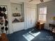 Bedroom with blue carpet offers built-in bookshelves, closet, and window with natural light at 511 Glencurry Dr, Charlotte, NC 28214