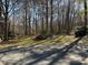 Landscaped front yard featuring mature trees and lush greenery for a private, serene setting at 511 Glencurry Dr, Charlotte, NC 28214