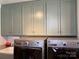 Laundry area has shaker cabinets, white tiled backsplash, with modern washer and dryer at 511 Glencurry Dr, Charlotte, NC 28214