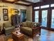 Cozy living room with wood floors, beamed ceilings, and French doors to a porch at 511 Glencurry Dr, Charlotte, NC 28214