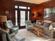 Elegant living room with wood paneling, comfortable seating and doors to outside deck at 511 Glencurry Dr, Charlotte, NC 28214