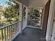 Relaxing covered porch has a white railing, brick column and lovely green trees and shrubs at 511 Glencurry Dr, Charlotte, NC 28214