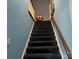 Stairway has blue walls, dark carpeted steps, and wooden railing leading upstairs at 511 Glencurry Dr, Charlotte, NC 28214