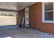 Covered back porch with a welcoming sign, adjacent to brick wall and yard view at 6231 Nc 16 N Hwy, Taylorsville, NC 28681
