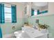 Bright bathroom with a window, classic teal tile, and a white sink at 6231 Nc 16 N Hwy, Taylorsville, NC 28681