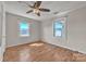 Bright bedroom with hardwood floors, ceiling fan, and views from two windows at 6231 Nc 16 N Hwy, Taylorsville, NC 28681