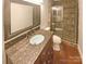 Modern bathroom featuring a stone tile shower, granite counter, and elegant mirror at 6606 Antrim Ct, Charlotte, NC 28217