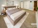 Beautifully staged bedroom with a large bed, soft rug, and neutral color scheme at 6606 Antrim Ct, Charlotte, NC 28217