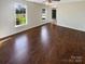 Bright living room with hardwood floors and large windows overlooking a well-maintained front yard at 6606 Antrim Ct, Charlotte, NC 28217