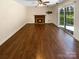 Open living room with hardwood floors, fireplace, and sliding glass door to the outside at 6606 Antrim Ct, Charlotte, NC 28217