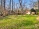 Expansive backyard featuring green grass, a storage shed, and mature trees at 6813 Linda Lake Dr, Charlotte, NC 28215