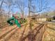 This fenced backyard features a playground, lawn and mature trees at 6813 Linda Lake Dr, Charlotte, NC 28215
