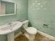 Half bathroom with pedestal sink, toilet, and decorative wallpaper at 6813 Linda Lake Dr, Charlotte, NC 28215