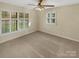 Well-lit carpeted bedroom with large windows, ceiling fan, and neutral decor at 6813 Linda Lake Dr, Charlotte, NC 28215