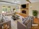 Staged living room featuring a brick fireplace, hardwood floors and large windows at 6813 Linda Lake Dr, Charlotte, NC 28215