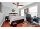 A well-lit bedroom with wood flooring, a ceiling fan, a desk, and windows offering natural light at 815 Oak Embers Se Dr, Concord, NC 28025