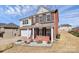 Beautiful two-story home featuring a brick exterior, attached garage, and landscaped yard with decorative elements at 815 Oak Embers Se Dr, Concord, NC 28025