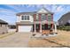 Two-story home boasts a brick facade, an attached garage, and a meticulously kept front yard with mature shrubs at 815 Oak Embers Se Dr, Concord, NC 28025