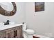 Stylish half bathroom with modern fixtures, vanity, decorative mirror and a charming rustic design at 815 Oak Embers Se Dr, Concord, NC 28025