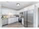 Updated kitchen featuring stainless steel appliances, white cabinets, granite countertops, and modern gray backsplash at 8322 Knights Bridge Rd, Charlotte, NC 28210