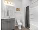 Bathroom featuring a single sink vanity, toilet, and a shower-tub combo with gray shower curtain at 840 Imperial Ct, Charlotte, NC 28273