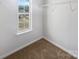 Walk-in closet with a window providing natural light and shelving for ample storage with carpeting at 9154 Bradstreet Commons Way, Charlotte, NC 28215