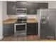Modern kitchen showcasing stainless steel appliances, dark cabinets, and stylish countertops on wood look flooring at 9154 Bradstreet Commons Way, Charlotte, NC 28215
