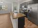 Modern kitchen with stainless steel appliances, island sink, and ample cabinet space at 9154 Bradstreet Commons Way, Charlotte, NC 28215