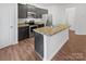 Close up of the kitchen island featuring stainless steel appliances and ample counter space with wood flooring at 9154 Bradstreet Commons Way, Charlotte, NC 28215