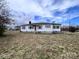 Quaint one-story home with white siding, a chimney, and a spacious front yard at 930 Weaver Rd, China Grove, NC 28023