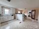 Eat-in kitchen with classic white cabinetry and views to another room with hardwood floors at 930 Weaver Rd, China Grove, NC 28023