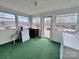 Bright and airy laundry room with multiple windows and green carpet at 930 Weaver Rd, China Grove, NC 28023