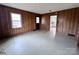 Traditional living room with wood paneling, a window, and a view to other rooms with hardwood floors at 930 Weaver Rd, China Grove, NC 28023