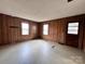 Living room with wood paneled walls and two windows, ready for a modern update at 930 Weaver Rd, China Grove, NC 28023