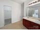 Bathroom with double vanity, large mirror, cherry cabinets and tiled floor and walk-in closet at 9407 Seamill Rd, Charlotte, NC 28278
