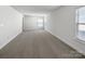 This bedroom features neutral walls, plush carpet, and a large window, offering a cozy atmosphere at 9407 Seamill Rd, Charlotte, NC 28278
