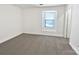 Bedroom with plush carpet, a large window bringing in natural light, and a neutral color palette at 9407 Seamill Rd, Charlotte, NC 28278