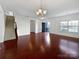 Bright living room featuring hardwood floors, stairs, large window, and modern chandelier at 9407 Seamill Rd, Charlotte, NC 28278