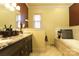 Bathroom with double vanity, soaking tub under window, dark wood cabinets, and marble countertop at 1001 Parkwood Ave, Charlotte, NC 28205